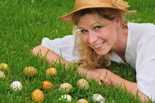 Young woman and easter eggs on grass - Easter time