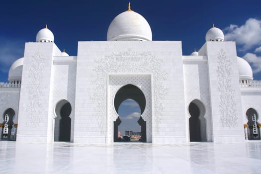 white mosque with cloudy blue sky