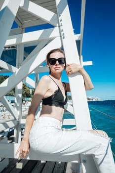 a woman in sunglasses stands by the stairs to the sea rest beach