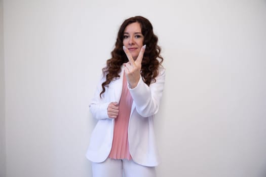 woman in a white suit points her fingers two