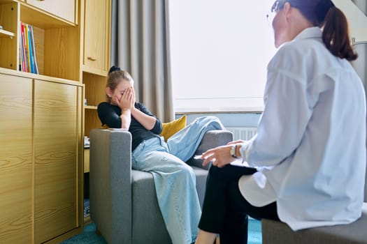 Girl child 10 years old at therapy session with psychologist. School counselor talking to child, listening, helping with problem. Mental health, childhood, schoolchildren, psychology, psychotherapy