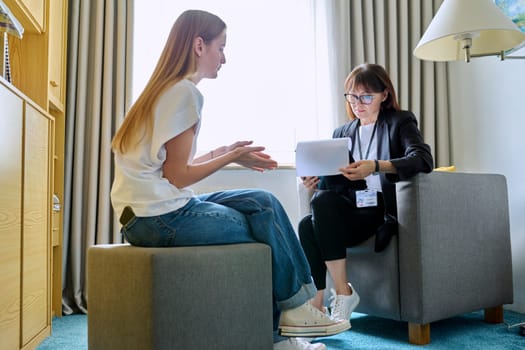 Female psychologist therapist working with young teen girl sitting in office. Teenage female student at therapy meeting with counselor. Psychology therapy psychotherapy youth mental health treatment