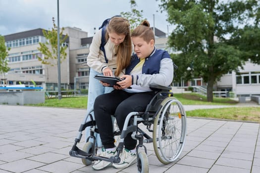 Children schoolchildren friends classmates together outdoor, girl and boy on wheelchair talking near school building. Education, friendship, communication, school, disability, inclusiveness concept