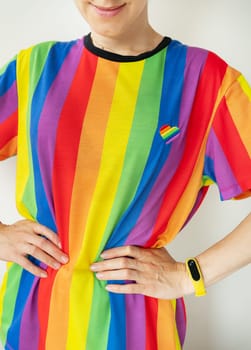 Young happy girl wearing a bright T-shirt in the colors of the LGBT flag. The concept of supporting the LGBT community