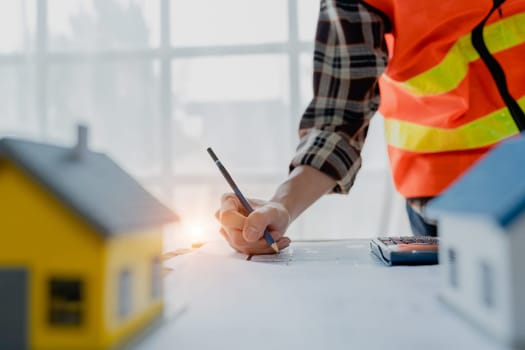 engineer brainstorming and measuring for cost estimating on blueprint and floor plan drawings about design architectural and engineering for houses and buildings.