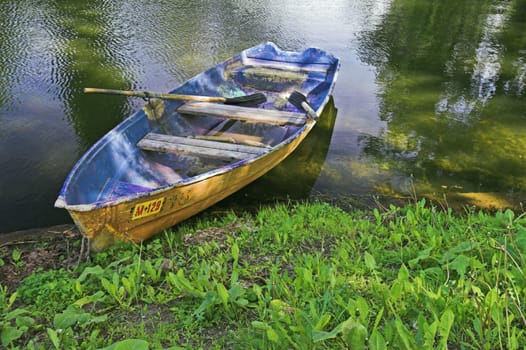 Boat at pond bank in summer park