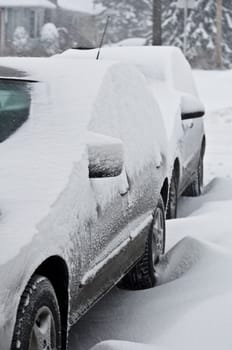 Two cars covered by snow, winter storm.