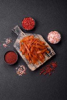 Jerky, dried turkey meat with salt and spices on a dark concrete background