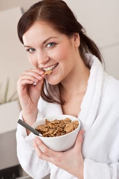 Young woman with cereals in kitchen