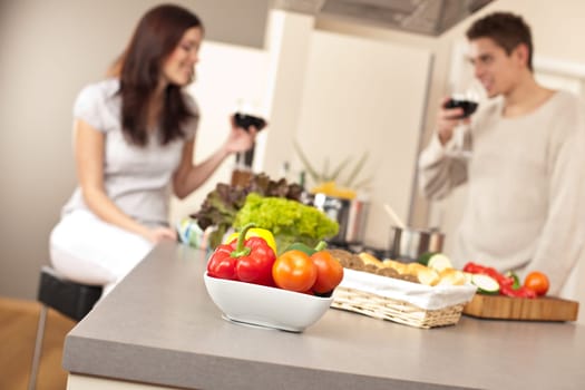 Young couple drink red wine in kitchen