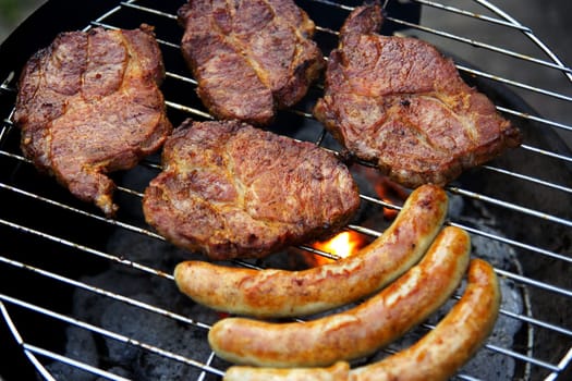 Grill with grilled meat and bratwurst in the garden