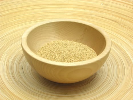 Wooden bowl with amaranth on bamboo plate