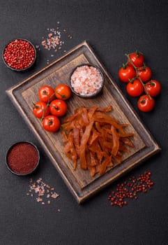 Jerky, dried turkey meat with salt and spices on a dark concrete background