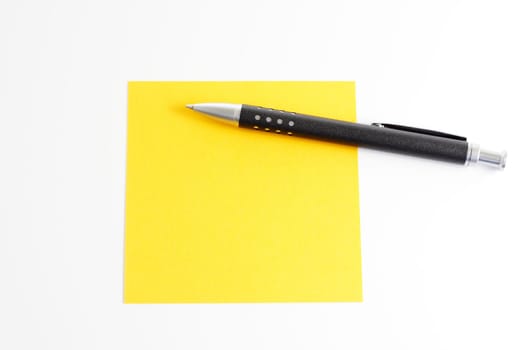 Yellow sticky note with ballpoint pen