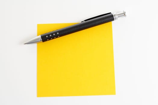 Yellow sticky note with ballpoint pen