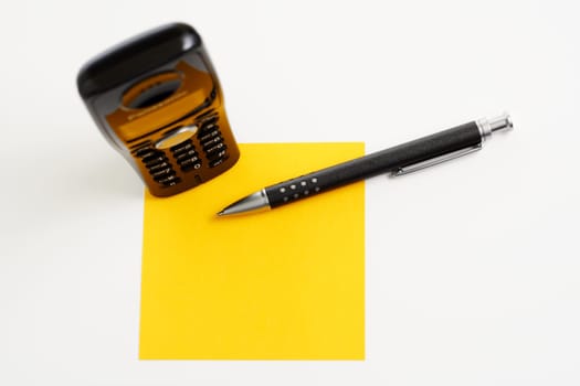 Yellow sticky note with ballpoint pen
