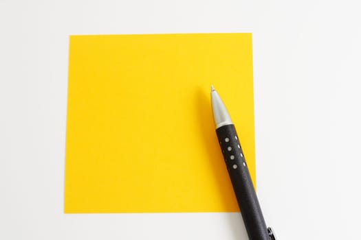 Yellow sticky note with ballpoint pen