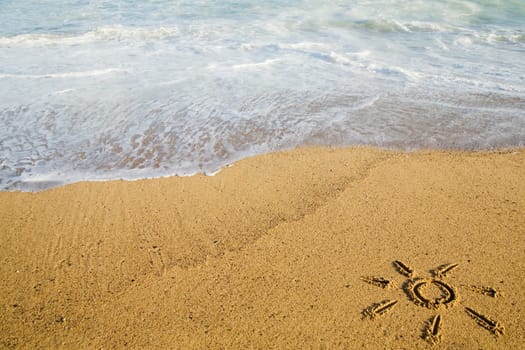 Sun painted on sand on beach