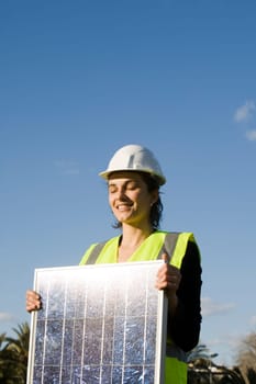 Woman holding a solar panel in front of a blah