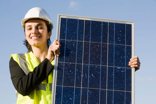 Woman holding a solar panel in front of a blah
