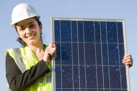 Woman holding a solar panel in front of a blah