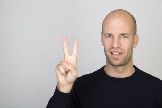 Man showing the number 2 with one finger