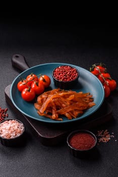 Jerky, dried turkey meat with salt and spices on a dark concrete background