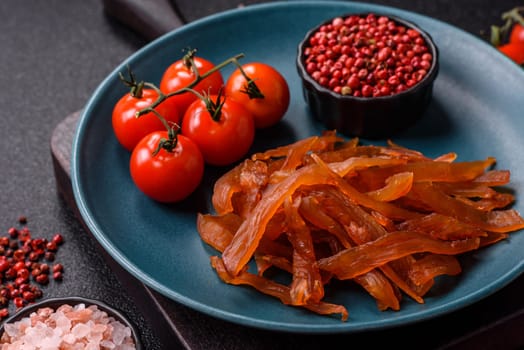 Jerky, dried turkey meat with salt and spices on a dark concrete background