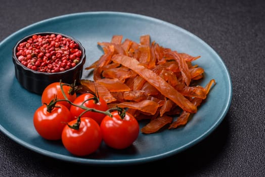 Jerky, dried turkey meat with salt and spices on a dark concrete background