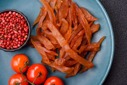 Jerky, dried turkey meat with salt and spices on a dark concrete background