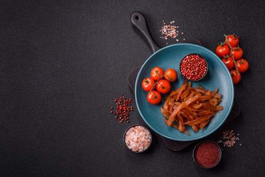 Jerky, dried turkey meat with salt and spices on a dark concrete background