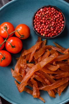 Jerky, dried turkey meat with salt and spices on a dark concrete background