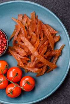 Jerky, dried turkey meat with salt and spices on a dark concrete background