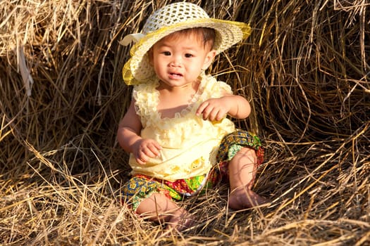 Baby girl from Asia in hay