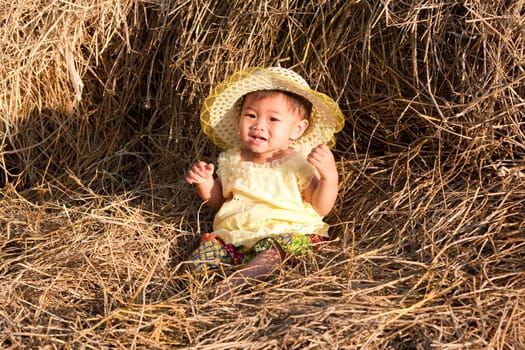 Baby girl from Asia in hay