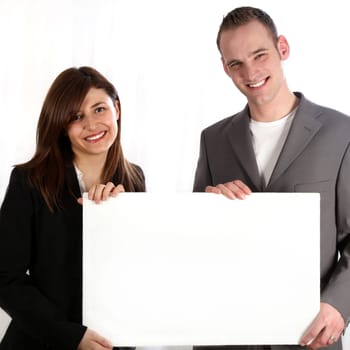 Woman and man laughing and holding blank white sign.