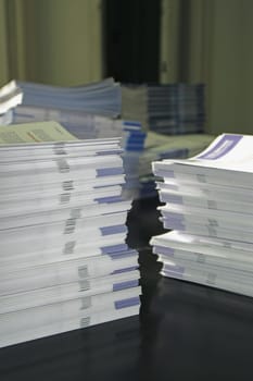 Piles of handout papers lying on a table.