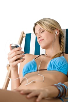 Beach - Young woman in bikini sitting on deck chair
