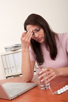 Woman at office take pill with headache