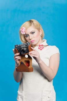 Blond girl look at retro camera