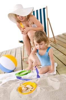 Beach - Mother with child playing with toys in sand