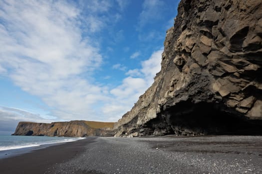 Black sand beach with Lundadrangur Rock Arch in Dyrholaey, South