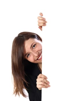 Young woman peeking behind a wall