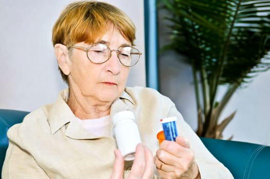 Elderly woman reading pill bottles