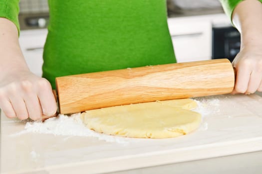 Hands with rolling pin and cookie dough