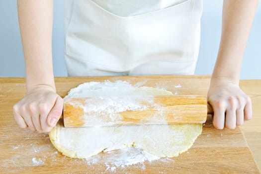 Hands with rolling pin and cookie dough