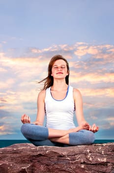 Young girl meditating at sunset