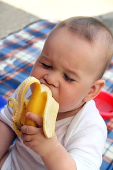 child eat yellow banana in outdoors