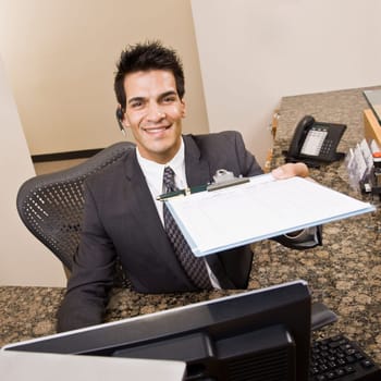 Man holding sign in sheet on clipboard. Square framed shot.