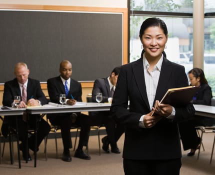 Businesswoman smiling holding folder. Horizontally framed shot.